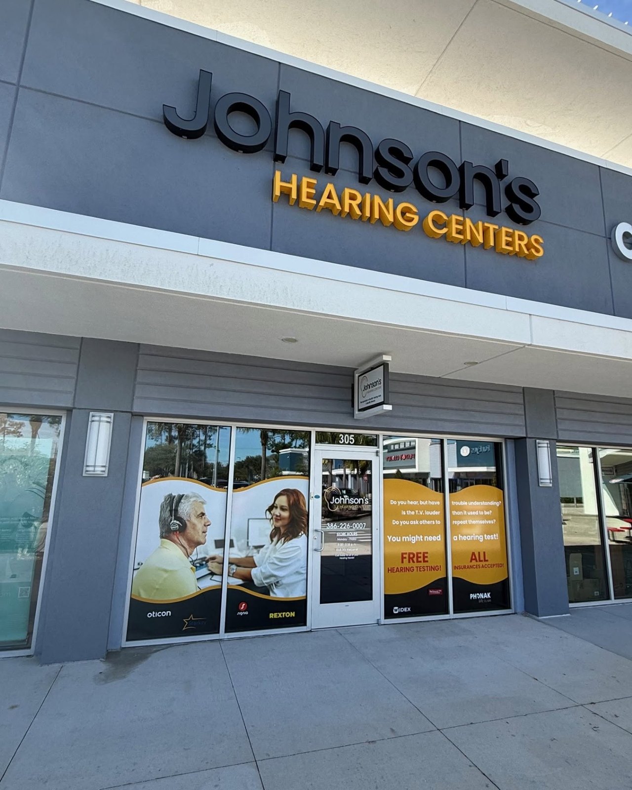 Full-color window vinyl graphics and door lettering on the Johnson's Hearing Centers storefront in Daytona Beach, FL
