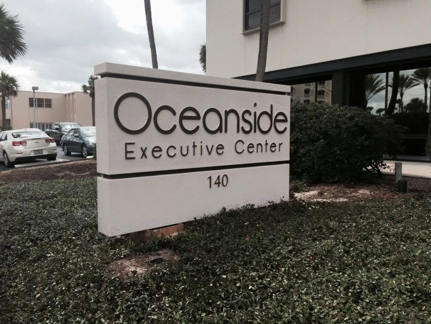 Oceanside Executive Center monument sign with dimensional letters and street number on a cream cabinet in Ormond Beach, FL